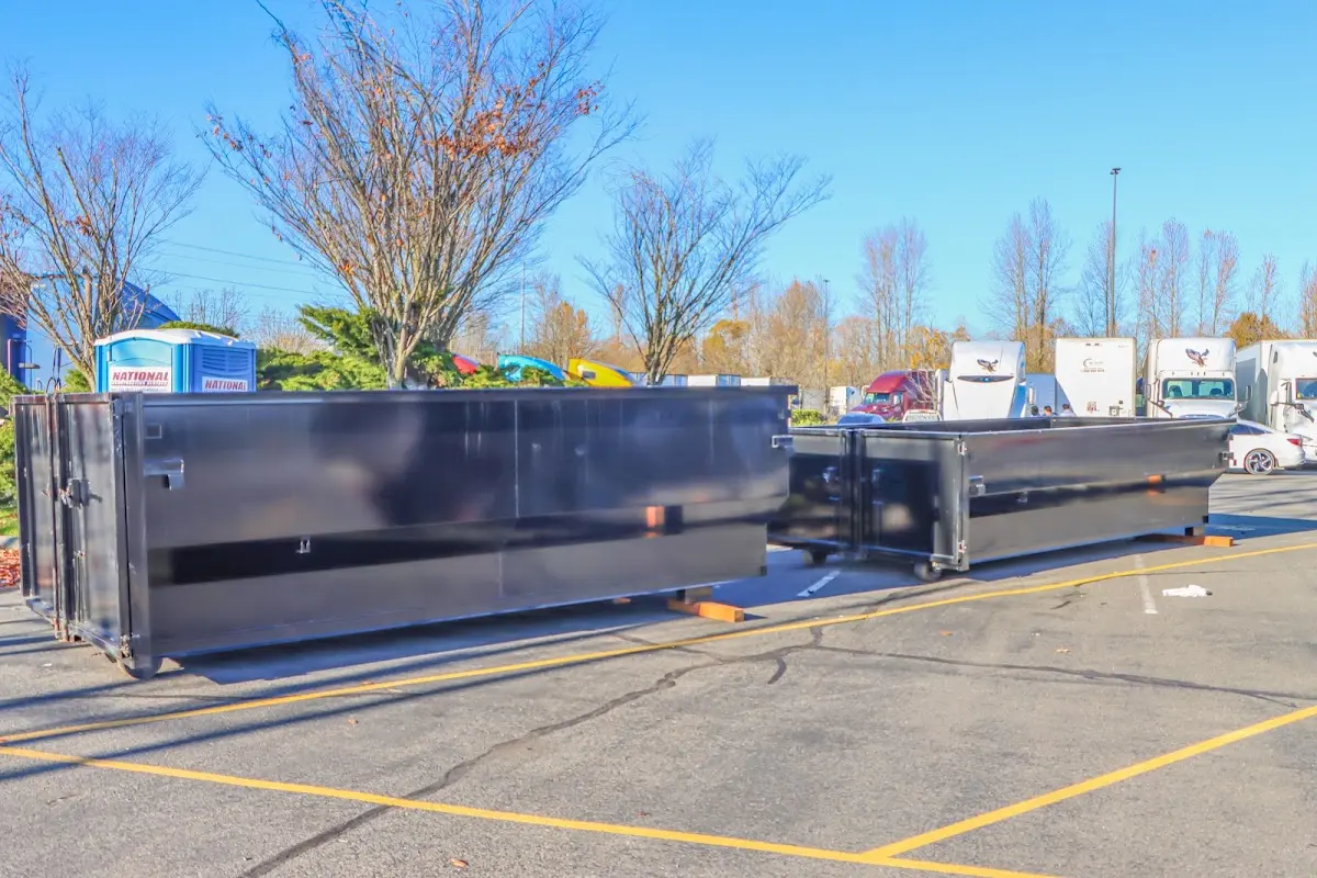 Professional dumpster rental service with roll-off container on residential driveway in Lisbon